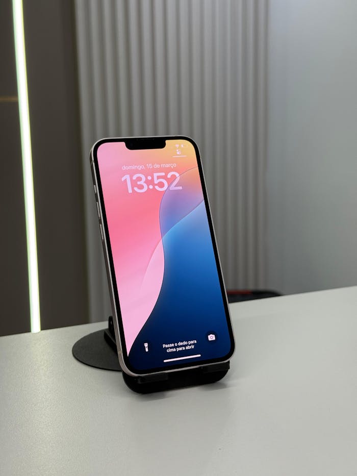 Close-up of a smartphone on a stand showing time and lock screen message.